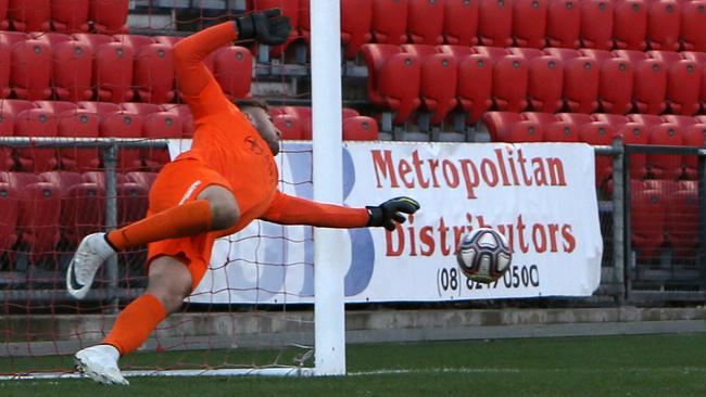 Goalkeeper Daniel Vaughan saves Marcos Flores’ penalty during Adelaide Olympic’s FFA Cup SA final victory against Adelaide City. Picture: AAP/Emma Brasier