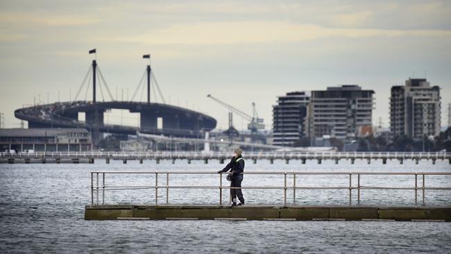 MELBOURNE, AUSTRALIA - NewsWire Photos AUGUST 31, 2021: A person looks out over a stormy Port Phillip Bay from Middle Park Beach on the last day of winter. Picture: NCA NewsWire / Andrew Henshaw