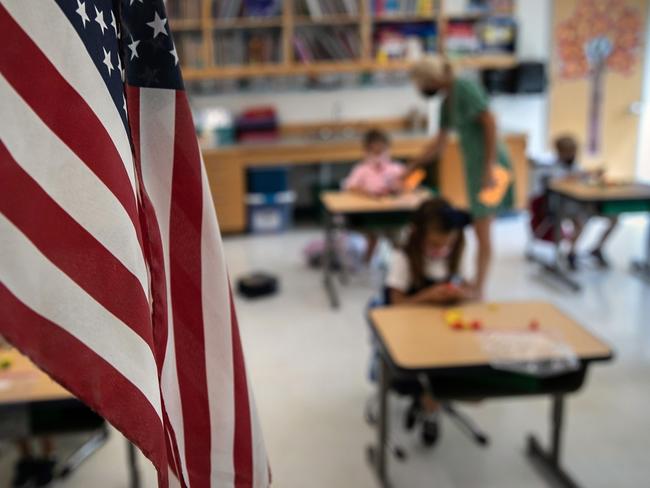 STAMFORD, CONNECTICUT - SEPTEMBER 09: Paraeducator Kim Caruso helps Harper Shea (5), on her first day of kindergarten on September 9, 2020 in Stamford, Connecticut. For millions of kindergarteners attending in-school classes for the first time, wearing masks and social distancing at school isn't just the new normal; it is the normal. Life in a time of coronavirus will forever be the way they began their scholastic career. Harper attends Rogers International School, a magnet K-8 school, which is part of Stamford Public Schools. The district is using a hybrid model, which includes both in-school classes and distance learning.   John Moore/Getty Images/AFP == FOR NEWSPAPERS, INTERNET, TELCOS & TELEVISION USE ONLY ==