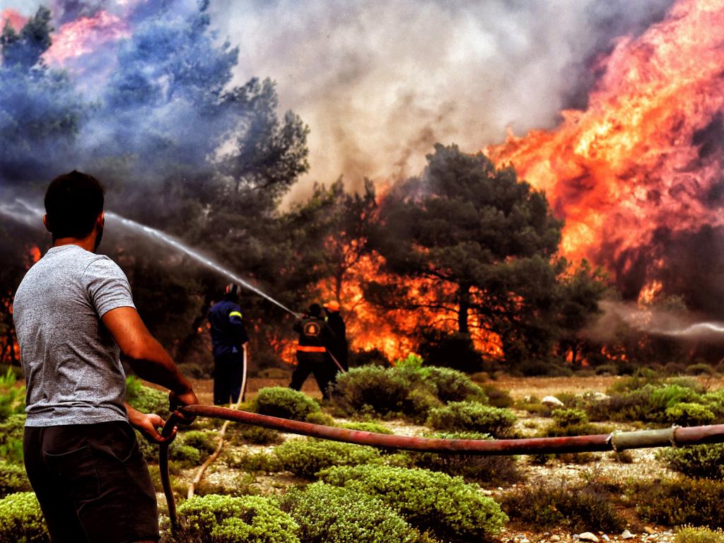 Firefighters and volunteers try to extinguish a wildfire raging in Verori, near Loutraki city, Peloponnese, southern Greece. Picture: EPA/VASSILIS PSOMAS