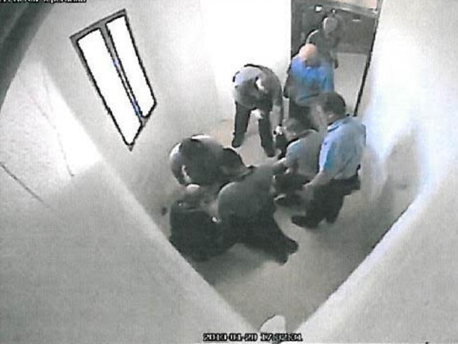 A 17-year-old boy being held down on the floor by staff at Townsville's Cleveland Youth Detention Centre.