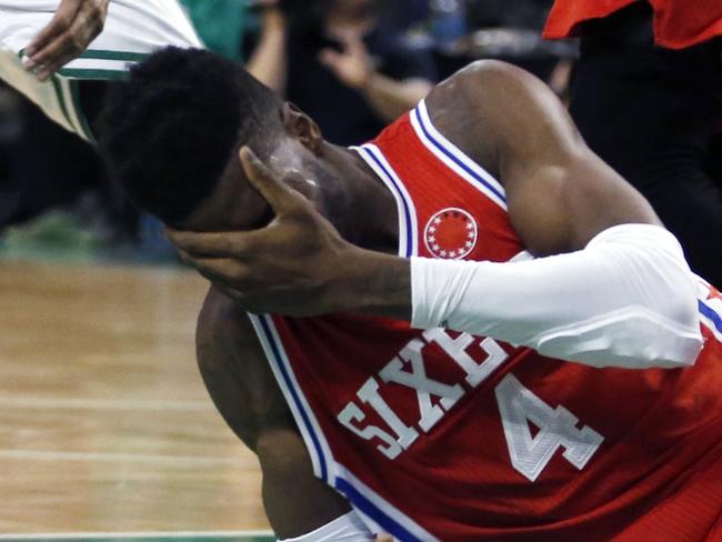 Boston Celtics' Evan Turner (11) and Philadelphia 76ers' Robert Covington (33) chase the ball as the 76ers' Nerlens Noel (4) holds his face after taking an elbow on a rebound during the third quarter of an NBA basketball game in Boston, Wednesday, Nov. 25, 2015. The Celtics won 84-80. (AP Photo/Michael Dwyer)