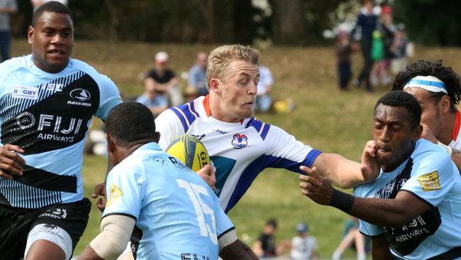 Stuart Dunbar from Greater Sydney Rams hands off a Fijian player. Pictures: Matt Sullivan