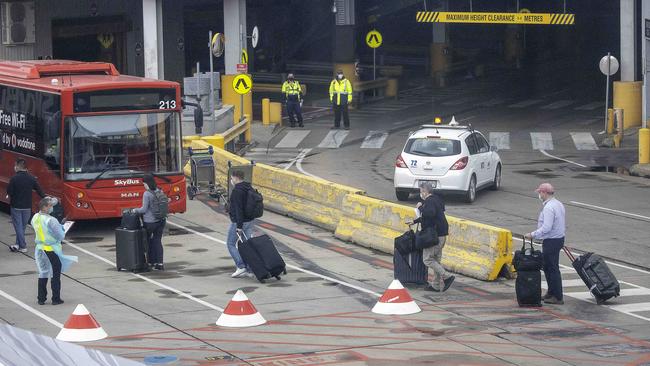 International arrivals walk to Skybuses after landing in Melbourne. Picture: Ian Currie