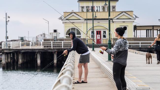 People fish on St. Kilda pier despite a fishing and hunting ban during Stage 3 lockdown. Picture: Jake Nowakowski