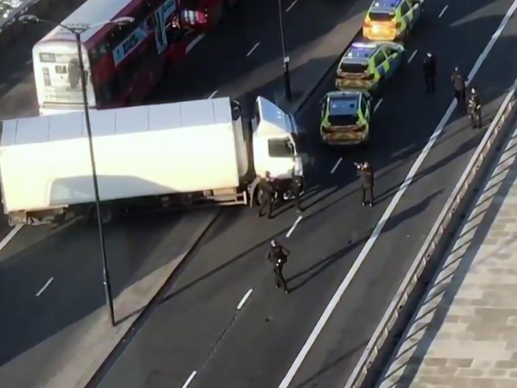 In this image made from video provided by Luke Poulton, armed police surround a truck parked across lanes of traffic on London Bridge. Picture: Luke Poulton via AP.