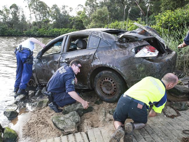 Police bring the dumped stolen car to the towing operation. Picture: Dylan Robinson