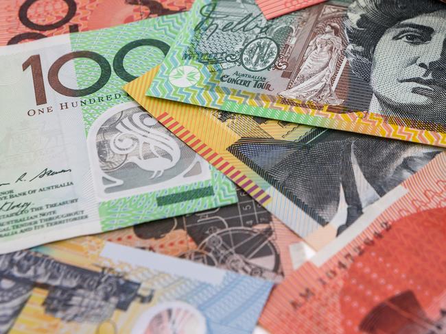 Calculator with wooden house model at australian dollars; property investment housing money generic