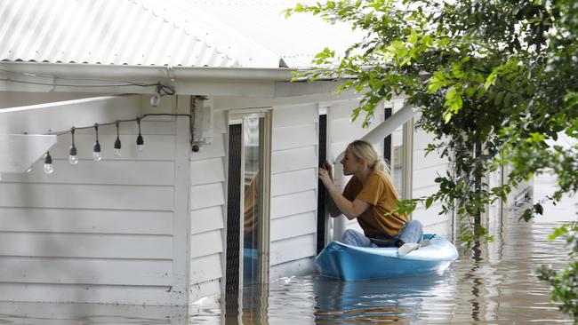 A resident inspects a flooded home in the Brisbane suburb of Fairfield during extensive flooding earlier this year. Picture: Tertius Pickard