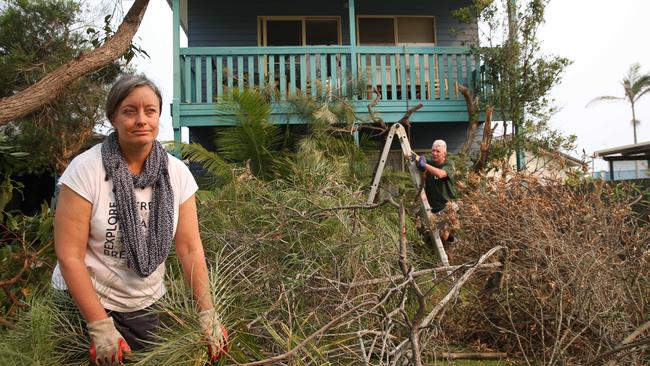 Melissa and David Clarke clear land around their home in preparation for ‘catastrophic’ conditions on Tuesday in Wallabi and elsewhere in NSW. Picture: Jane Dempster