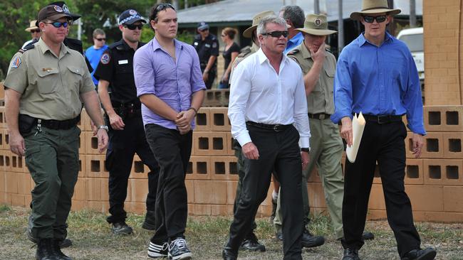 Zak Grieve (third from left) accompanies police to the crime scene.