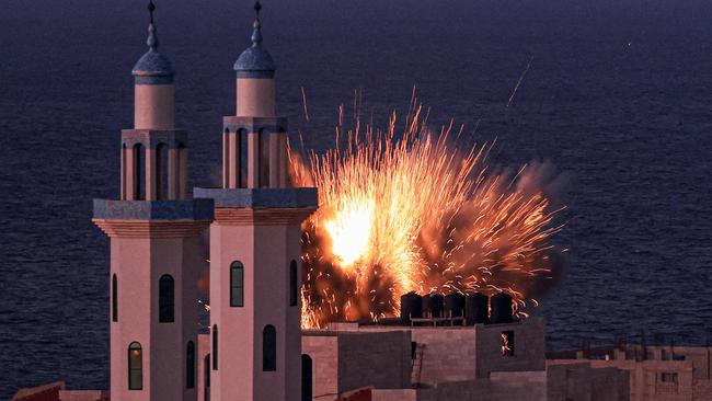 A fireball erupts from an Israeli airstrike in Gaza City on October 12.