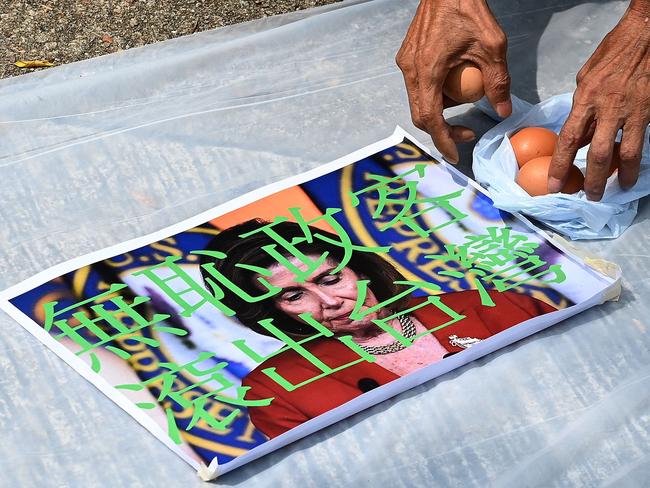 A pro-Beijing protester prepares to throw eggs at an image depicting the US House Speaker Nancy Pelosi at a protest outside the US Consulate in Hong Kong. Picture: AFP