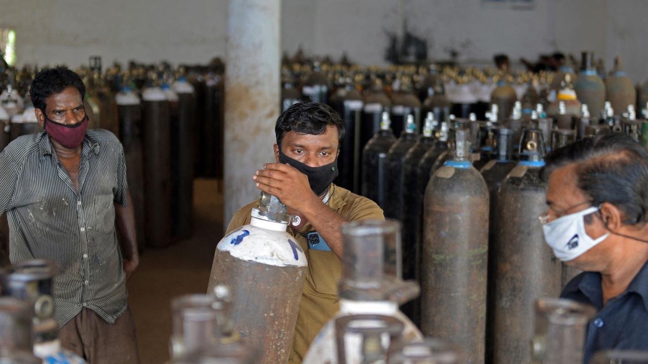 Workers arrange medical oxygen cylinders to be transported to hospitals. Picture: Arun Sankar / AFP