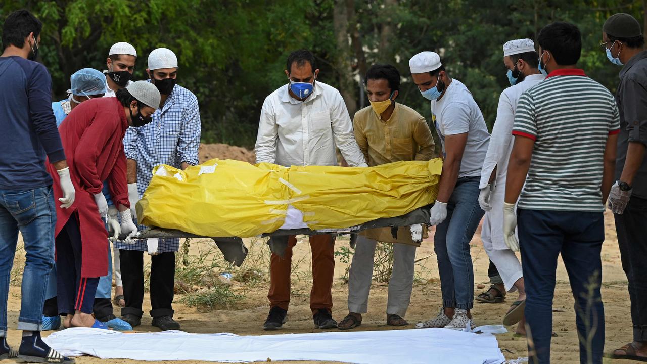 Relatives and friends carry the body of a COVID-19 victim in a New Delhi graveyard. Picture: AFP