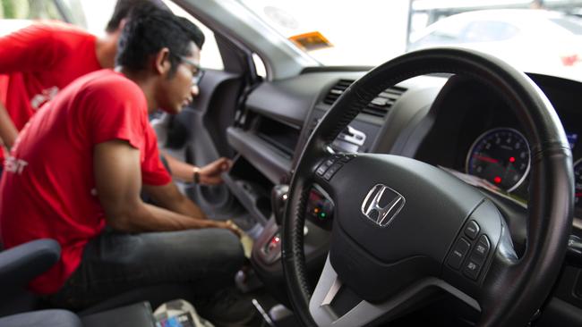 A Honda technician replaces a faulty Takata airbag. A loophole in the recall process means that private sellers in Australia of affected cars don’t have to tell buyers about the recall.