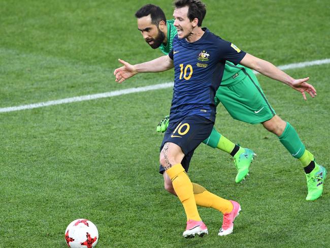 Chile's goalkeeper Claudio Bravo vies with Robbie Kruse.