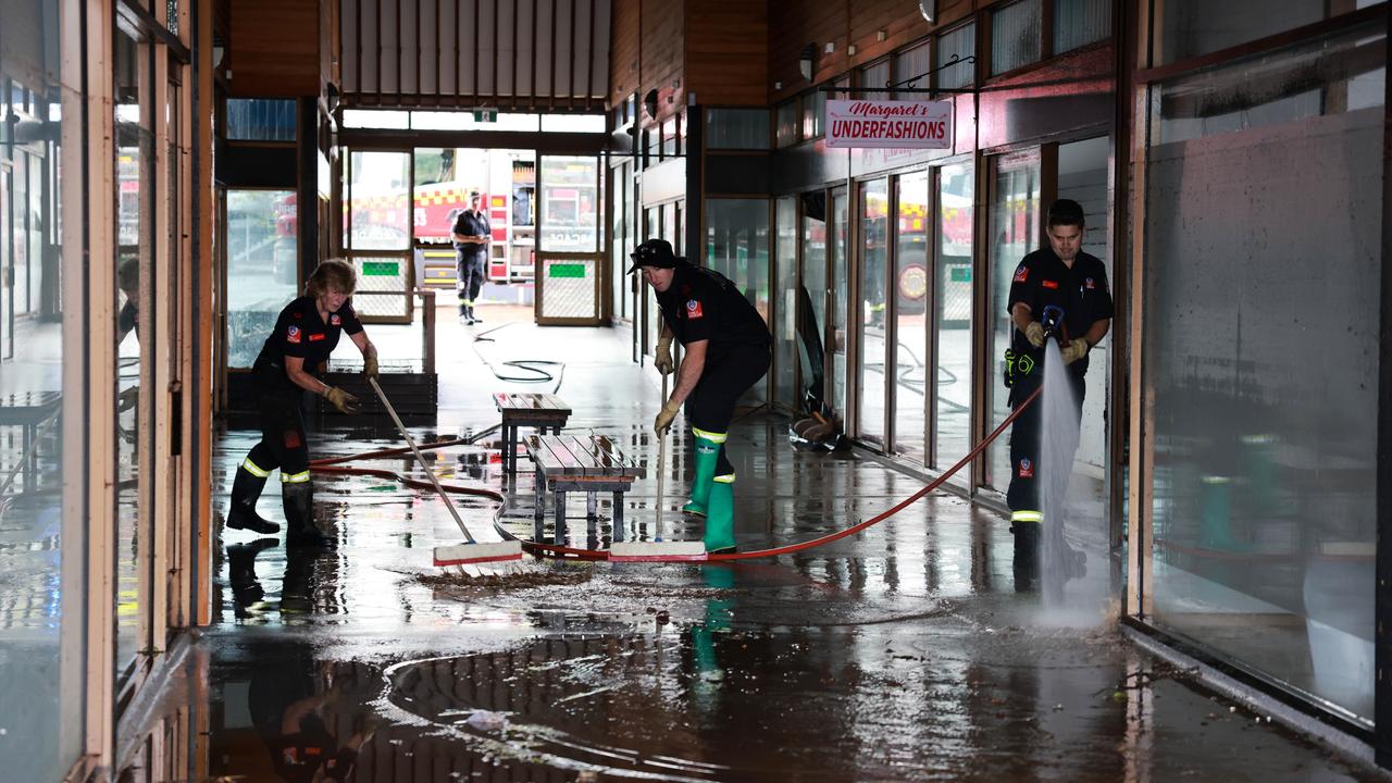Fire and Rescue workers Sue Taylor, Ricky Campbell and Luke remove mud and debris from the town centre after devastating floodwaters that swept through Taree. Picture: NewsWire / Scott Calvin
