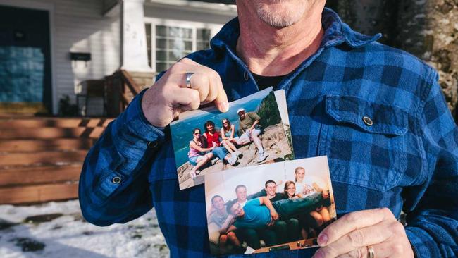 Young holds up photos of his family, outside the home where he wrote his best-selling novel. Picture: Jason Quigley