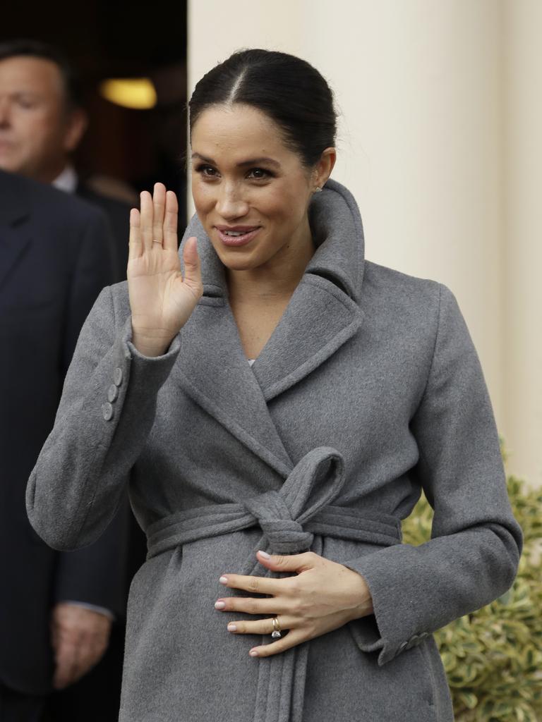 Meghan cradled her stomach during the visit. Picture: AP 