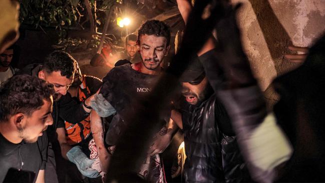 Palestinian civil defence evacuate a wounded man from a house destroyed by the Israeli bombardment of Rafah this week. Picture: AFP