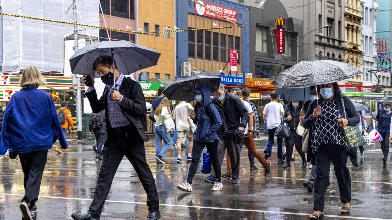 Melburnians walking through the evening’s downpour. Picture: David Geraghty