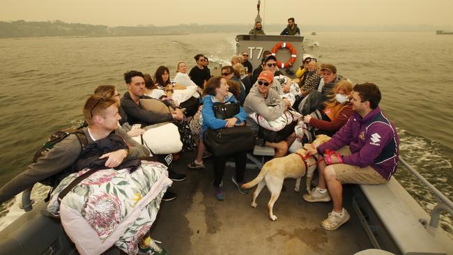 All smiles and laughter as a boatload of evacuees leaves Mallacoota for HMAS Choules. Picture: David Caird