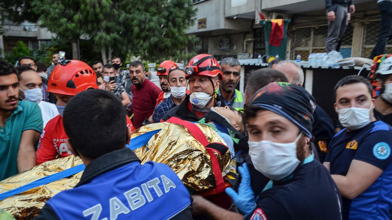 Rescuers and local volunteers carry a wounded victim from a collapsed building in Izmir. Picture: AFP.