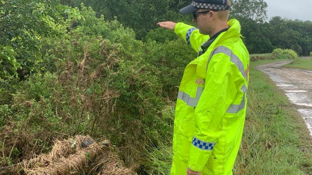 The scene of a massive search for missing Gympie dad Phil Lambert. Maryborough tactical crime squad police officer Brendan Hindle shows the height of the flood waters as they raged through Greens Creek on Wednesday night.