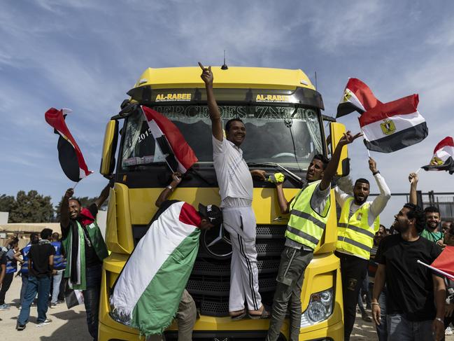 Volunteers and staff celebrate after unloading aid supplies and returning to the Egyptian side of the border. Picture: AFP