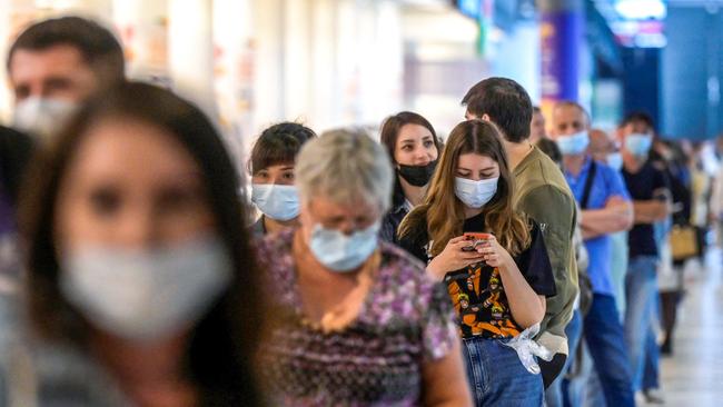 People wearing protective face masks queue for their vaccination. Picture: AFP