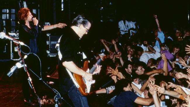 Hutchence and guitarist Kirk Pengilly onstage in front of a moshing crowd. Picture: Supplied.