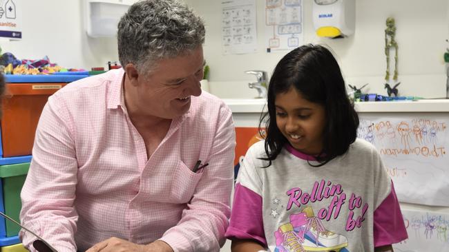 Education Minister Mark Monaghan reads to a Royal Darwin Hospital school student. Picture: SIerra Haigh