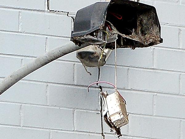 The broken street light that may have broken the truck drivers 20meter fall.   A truck overhangs off City link  at North Melbourne, The truck driver landed 20 meters below in Mark Street North Melbourne.