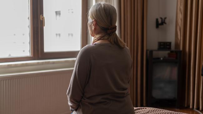 Senior Woman Sitting on Bed and Looking Away from the Window