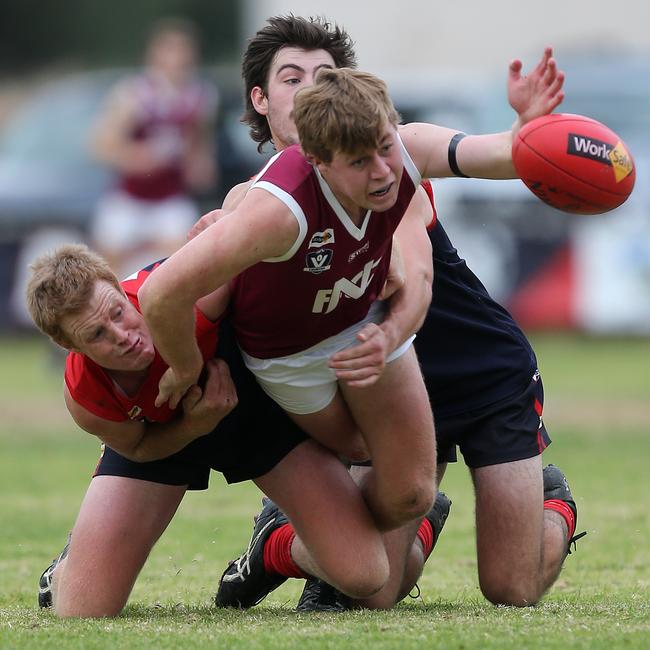 Nullawil’s Billy Forrester has eyes for the ball despite being tackled by Wycheproof-Narraport coach Boe Bish, left, and Jack McHutchinson. Pictures: Yuri Kouzmin