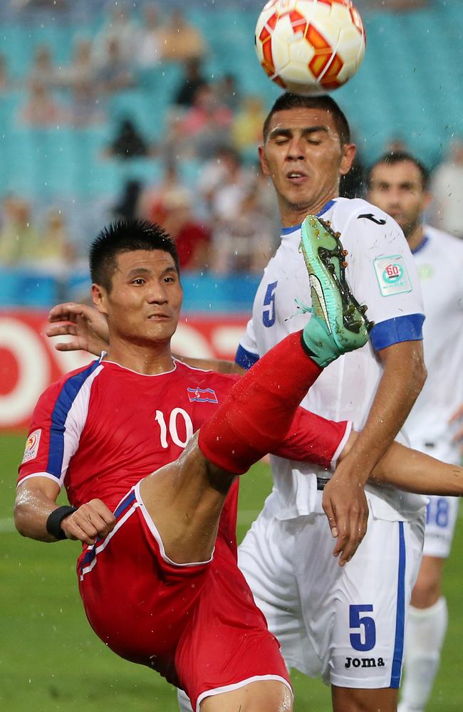 North Korea’s Pak Kwang Ryong gets a kick out of the Uzbekistan defence.