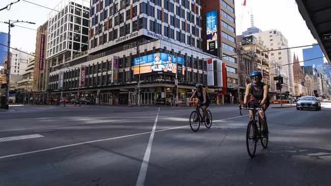 Cyclists on a deserted Flinders St. Picture: Daniel Pockett/Getty Images