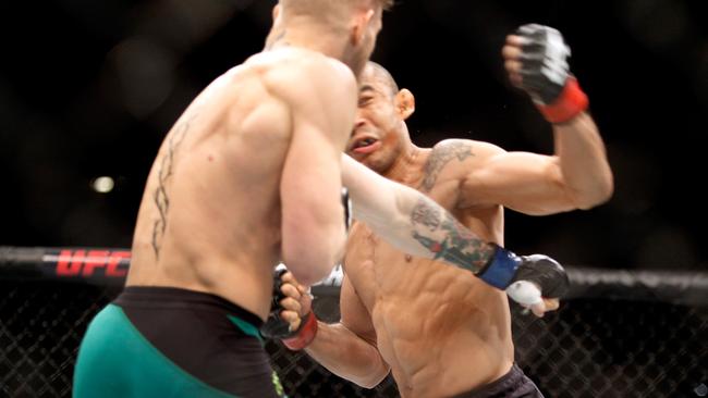 Conor McGregor (L) knocks out Jose Aldo at UFC 194.