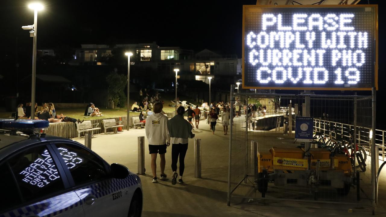 Police performing Covid compliance checks of people as they enjoy their Friday night at Biddigal Reserve at Bondi Beach. Picture: Jonathan Ng