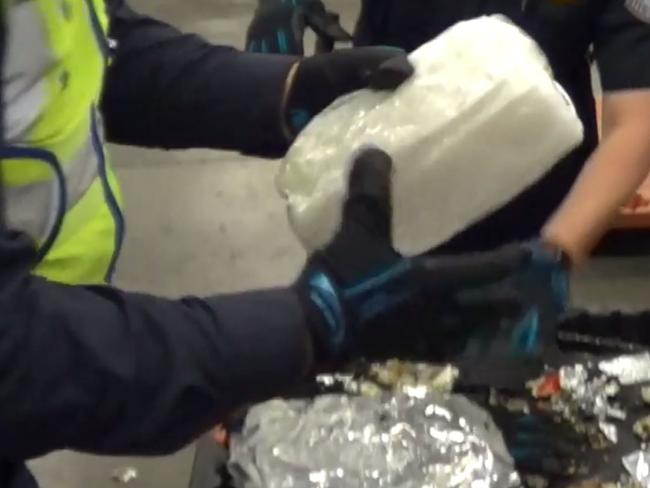 Police handling drugs hidden in car speaker parts. Source: AFP