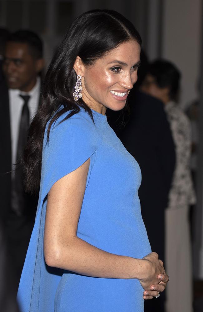 Meghan cradled her bump as she arrived at the event. Picture: Ian Vogler