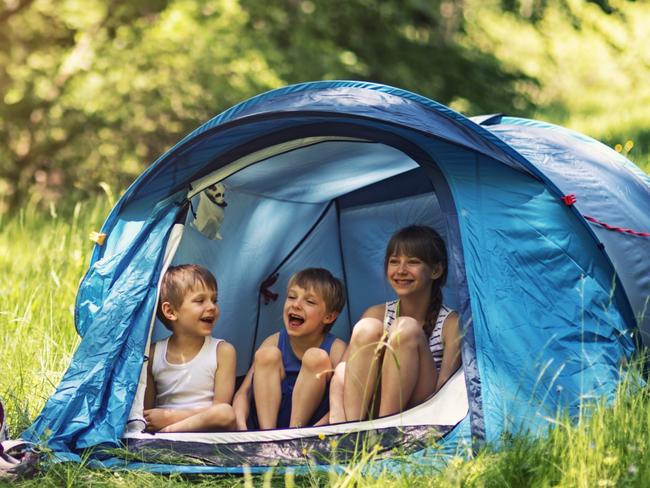 SHFG. Little girl and brothers are camping in a tent in a sunny forest. Picture: iStock