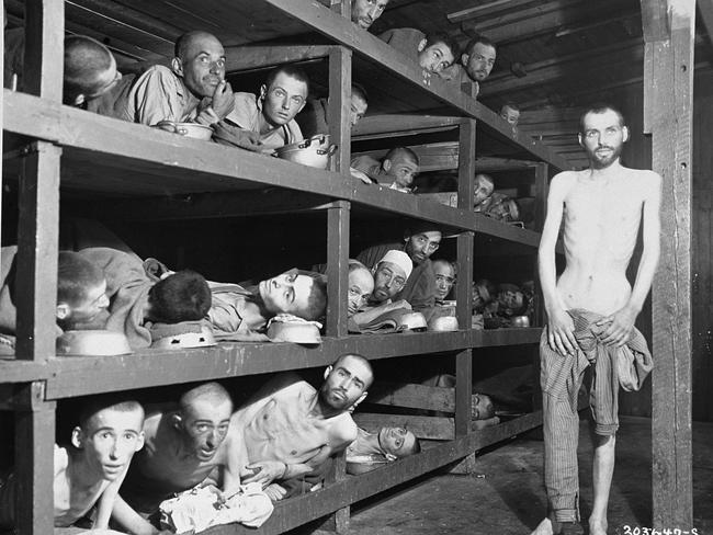 Former prisoners of the ‘little camp’ in Buchenwald stare out from the wooden bunks in which they slept three to a ‘bed’. Picture: Supplied.