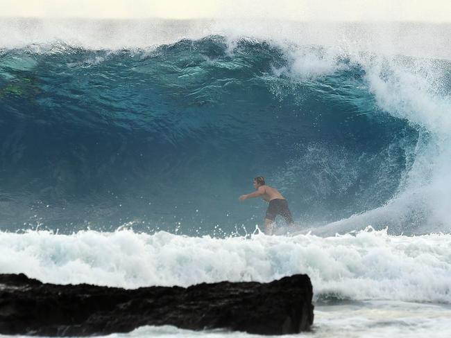 A surfer is seen at Snapper Rocks on the Gold Coast , Thursday February 21, 2019. Huge swells and high tides are set to pummelling south-east Queensland beaches over the coming days as Cyclone Oma tracks towards the Queensland coast. (AAP Image/Dave Hunt)