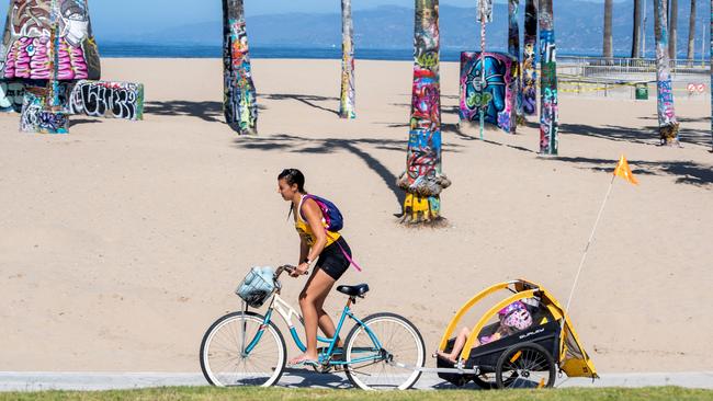 A person rides on the bike path on Venice Beach, California. The County only allowed activities such as running, walking, swimming and surfing with sunbathing and volleyball not allowed.