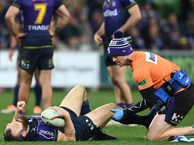 MELBOURNE, AUSTRALIA - AUGUST 26:  Tom Eisenhuth of the Storm is attended to by a team trainer after an injury during the round 24 NRL match between the Melbourne Storm and the Sydney Roosters at AAMI Park on August 26, 2022, in Melbourne, Australia. (Photo by Quinn Rooney/Getty Images)