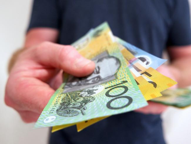 A man handing out Australian dollar bills. A picture that describes buying, paying, handing out money, or showing money.