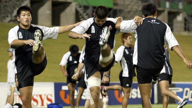 Members of Japan's rugby team warm up at the start of a practice session in Townsville, Queensland October 22, 2003 in preperation for their World Cup rugby Pool B match with Fiji on Thursday. REUTERS/Darren Whiteside