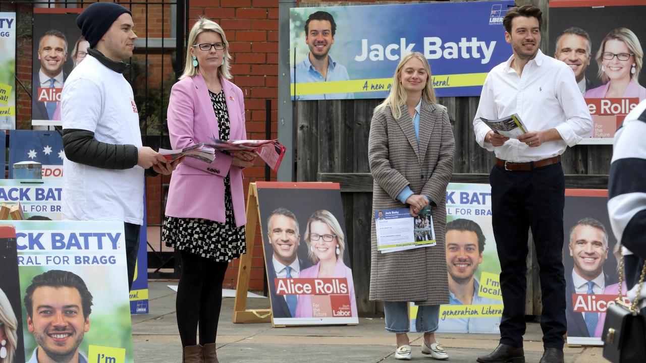 Bragg candidates Alice Rolls, (pink jacket) and Jack Batty (white shirt) with wife Charlotte,(long grey coat) at the Glenunga High School on 2 July 2022. Picture Dean Martin